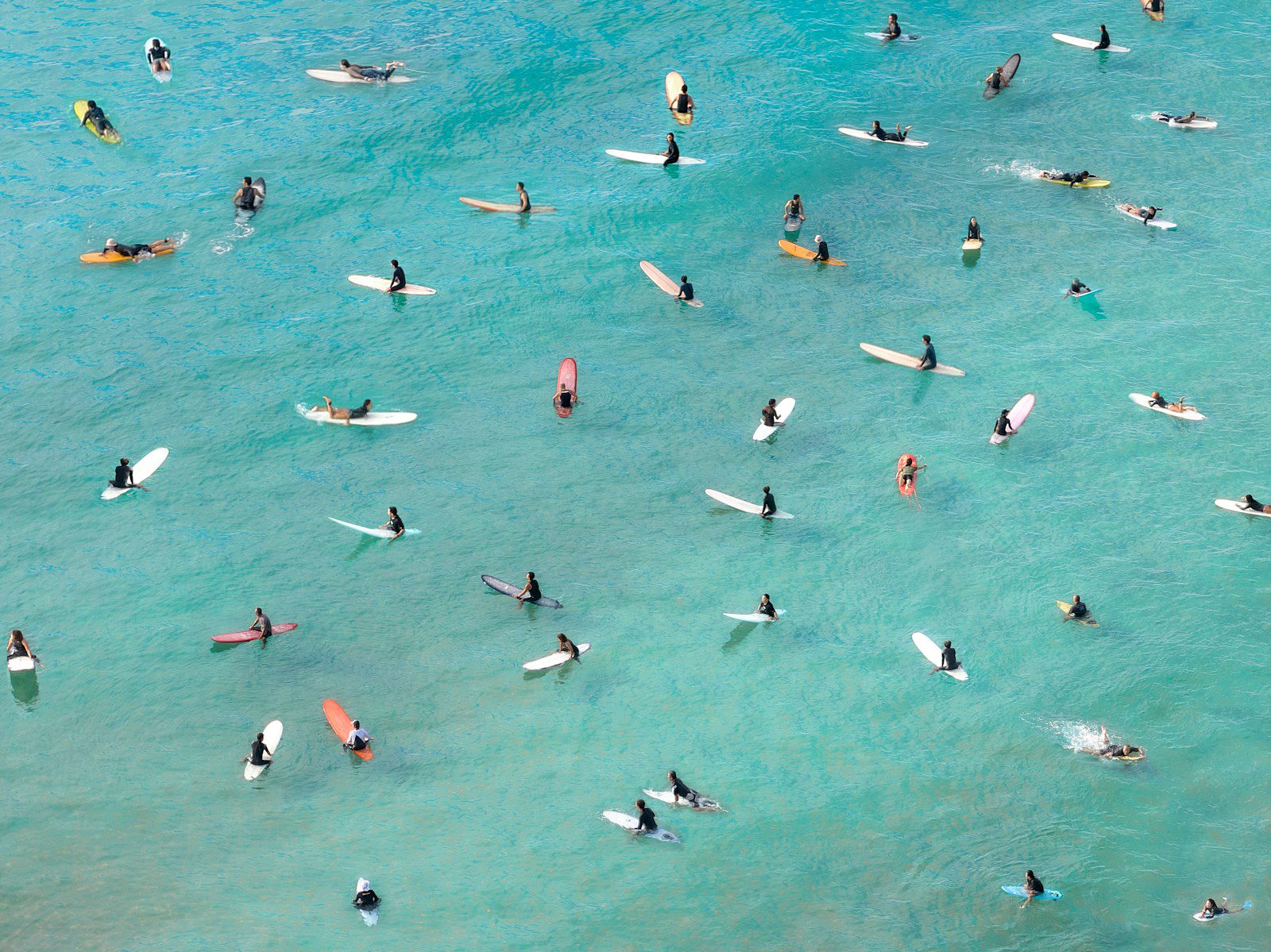 Surfers paddling on blue ocean waves