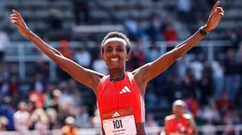 Shewarge Alene running in a stadium during a long-distance race